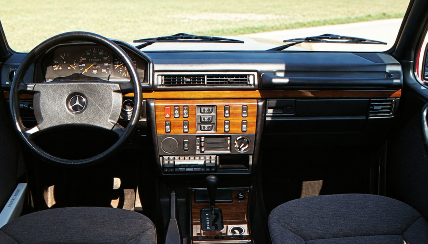Abitacolo della Mercedes 300 GE della prova, con inserti in legno sulla plancia — restauro assistito da IA dalla scansione originale