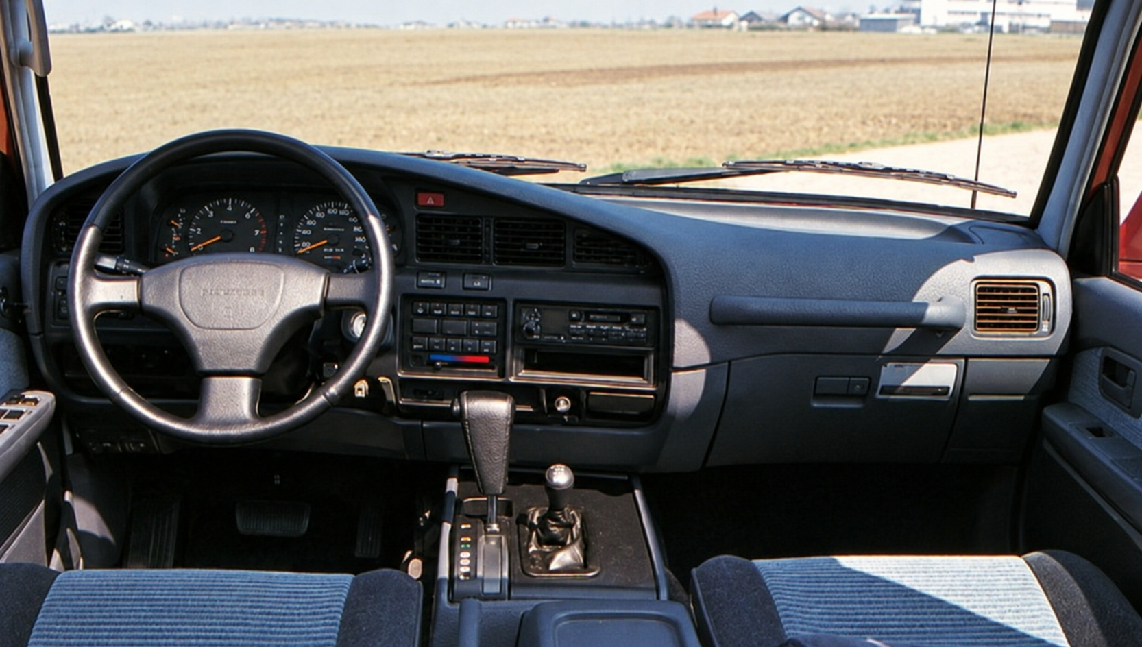 Posto guida della Toyota Land Cruiser HDJ 80 fotografato nel servizio originale — restauro assistito da IA dalla scansione originale