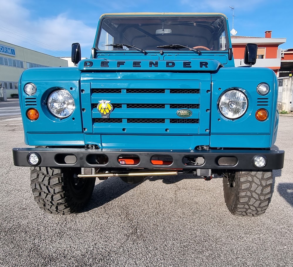 Vista frontale del Defender 110 turchese con capote sabbia